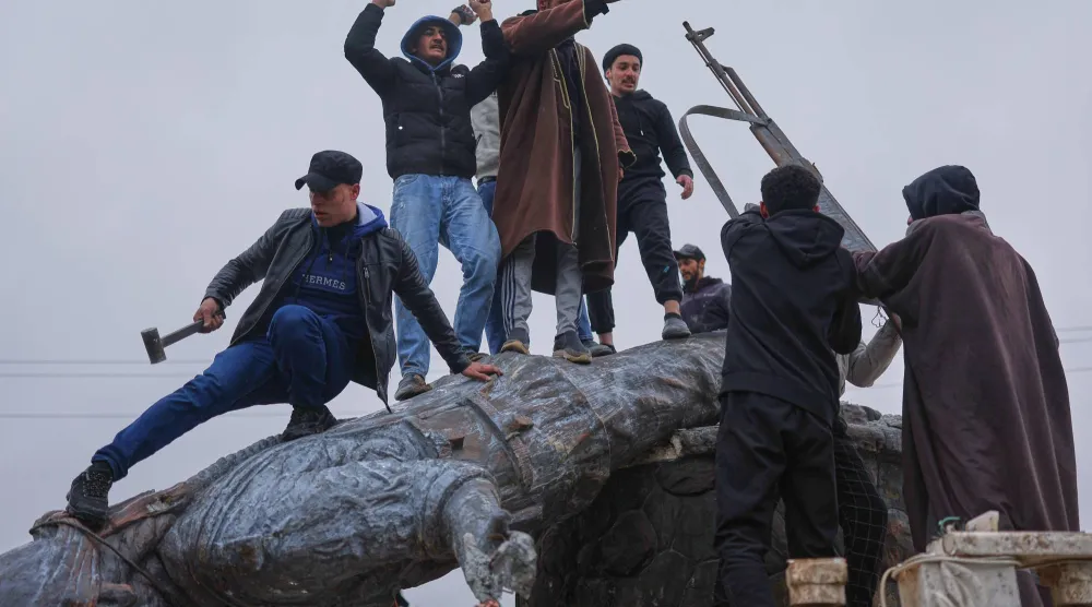 قام سكان بإسقاط تمثال لمقاتلة كردية بعد سيطرة قوات الجيش السوري على البلدة من «قوات سوريا الديمقراطية» المدعومة من الولايات المتحدة (أ.ب)