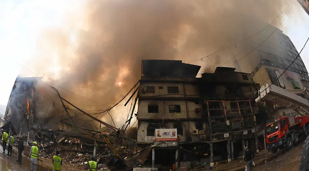 رجال الإطفاء وهم يكافحون حريقاً هائلاً في مركز جول بلازا التجاري بمدينة كراتشي (إ.ب.أ)