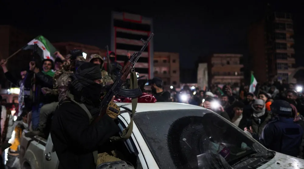 أفراد من الجيش السوري يحتفلون بدخول مدينة الرقة عقب انسحاب «قوات سوريا الديمقراطية» (رويترز)