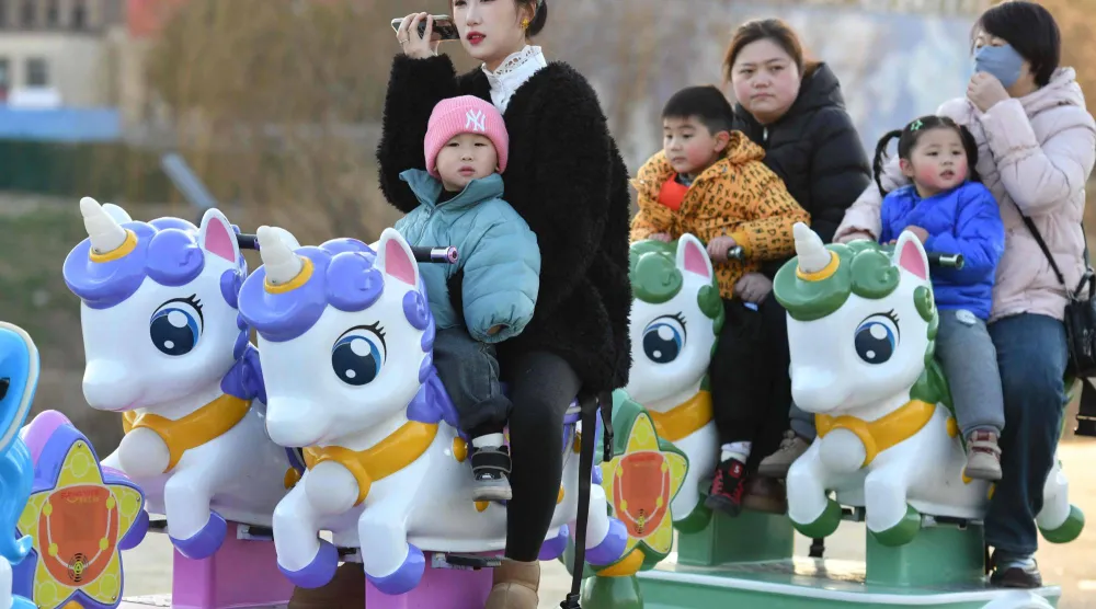 أطفال يهلون في متنزه بمدينة فويانغ شرق الصين (أ.ف.ب)