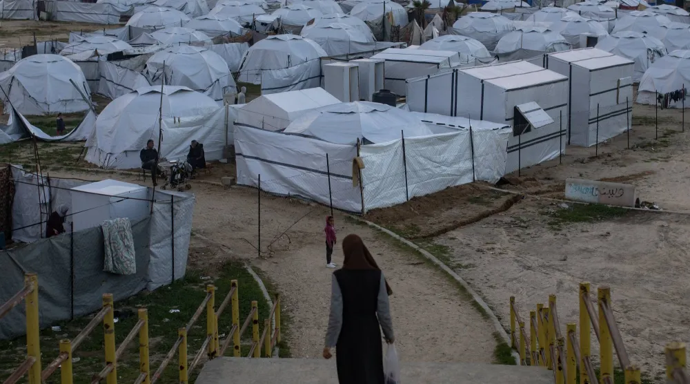 سيدة فلسطينية أمام خيام مؤقتة أقيمت بمدينة خان يونس جنوب قطاع غزة (إ.ب.أ)