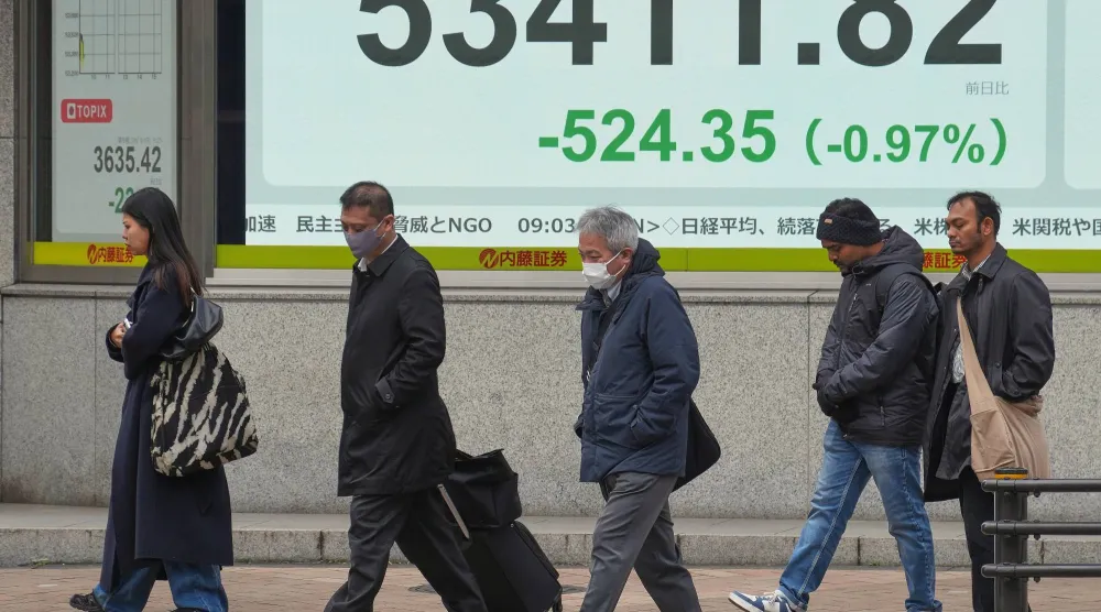 شاشة إلكترونية تعرض حركة الأسهم في وسط العاصمة اليابانية طوكيو (أ.ب)