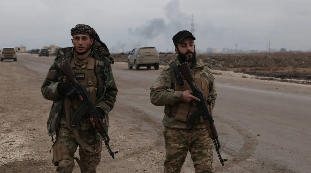 عنصران من القوات الحكومية السورية في الرقة الأحد (أ.ف.ب)