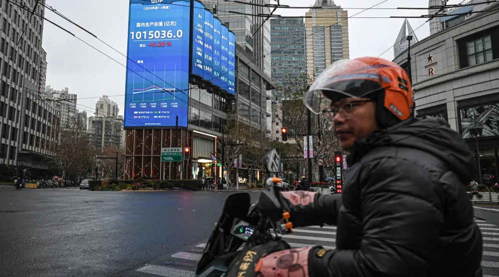 رجل على دراجة نارية في أحد شوارع مدينة شنغهاي الصينية (أ.ف.ب)