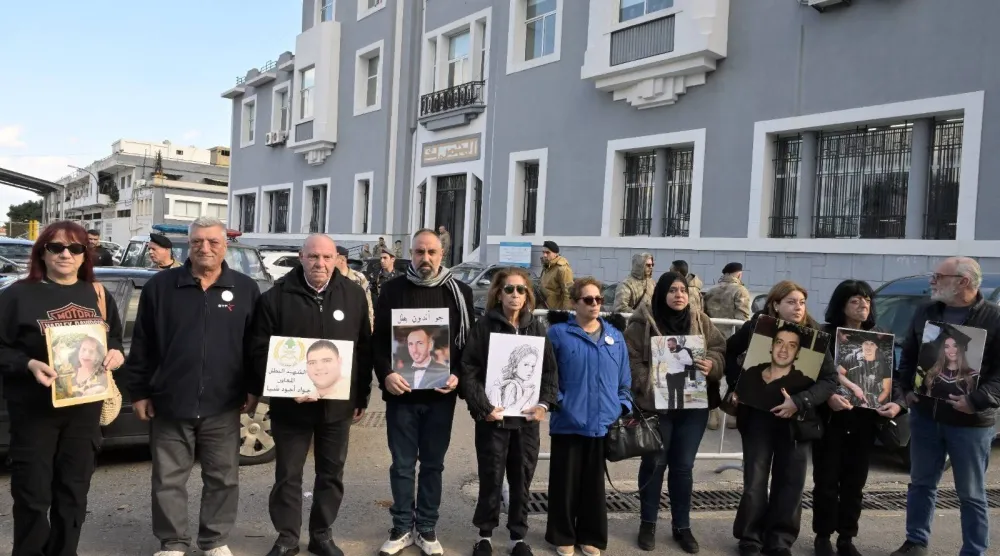 أهالي الضحايا يرفعون صور أبنائهم الذين قُتلوا في انفجار مرفأ بيروت يوم 4 أغسطس 2020 (الشرق الأوسط)