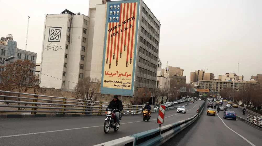 Iranians drive near an anti-US mural in street in Tehran, Iran, 19 January 2026. (EPA)