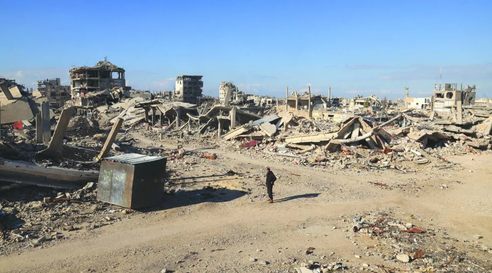 
فلسطيني يقف قرب أنقاض منزل عائلته في خان يونس جنوب غزة ويواصل البحث عن أقاربه المدفونين تحت الأنقاض (رويترز)