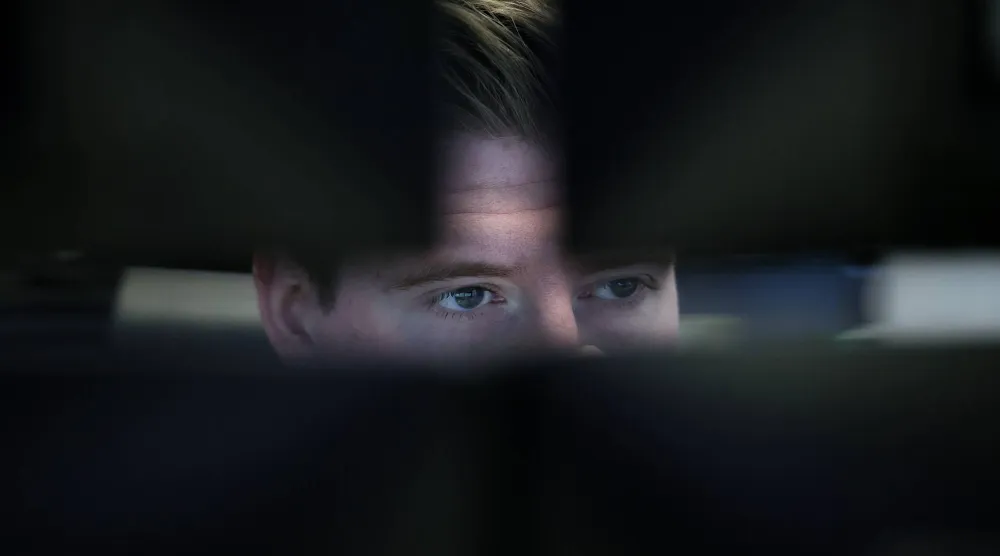 وسيط يراقب أسعار الأسهم في قاعة التداول ببورصة فرانكفورت (إ.ب.أ)