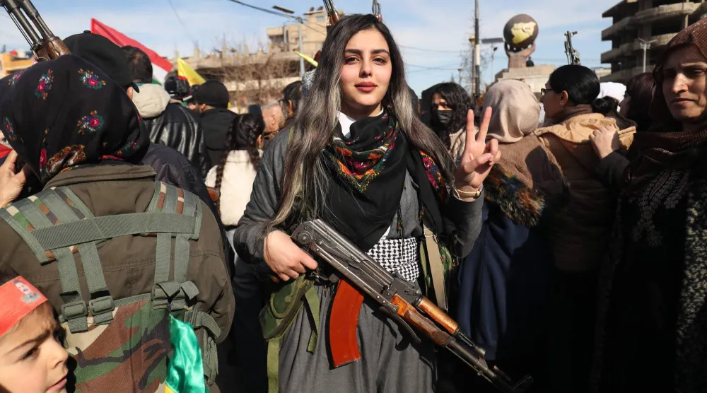 مدنيون أكراد يتجمعون بأسلحتهم في مدينة القامشلي (أ.ف.ب)