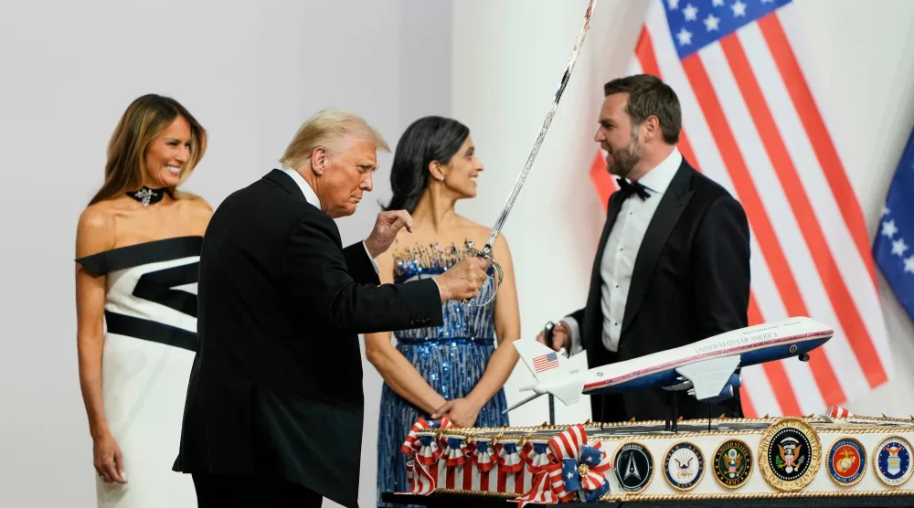 الرئيس دونالد ترمب يحمل سيفاً بعد استخدامه لتقطيع كعكة في حفل في واشنطن (أ.ب) 