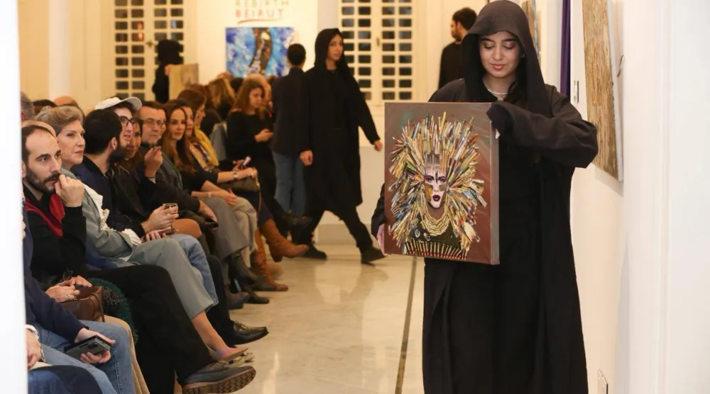 فتيات يحملن لوحات هبة الخطيب أمام الجمهور (ريبيرث بيروت)