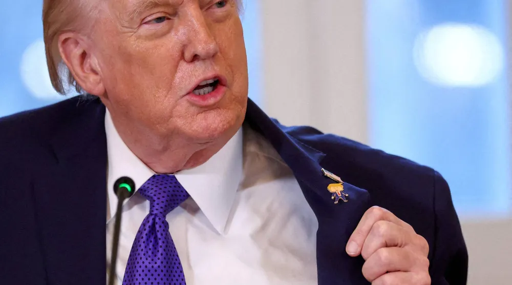 الرئيس الأميركي دونالد ترمب يُظهر ما أسماه دبوس «ترمب السعيد» أثناء حضوره اجتماعاً مع مسؤولين تنفيذيين في صناعة النفط بالبيت الأبيض (رويترز)