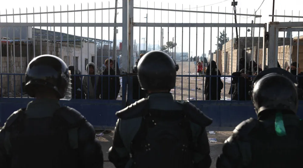 قوات الأمن الداخلي السورية تقف حراسة عند مدخل مخيم الهول في المنطقة الصحراوية بمحافظة الحسكة السورية (أ.ف.ب)