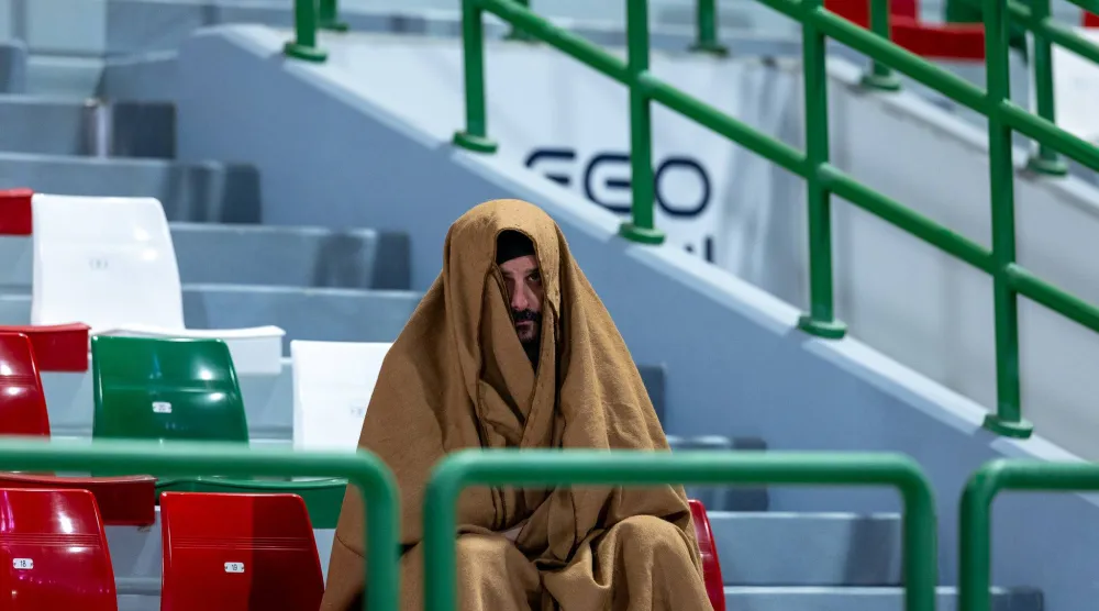 مشجع اتفاقي يتابع أحداث مباراة فريقه أمام نيوم وسط أجواء شديدة البرودة (تصوير: عيسى الدبيسي) 