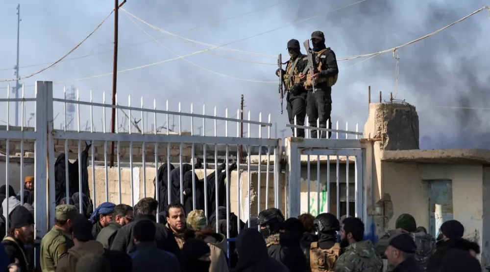 Haseke’deki el-Hol kampında bir grup tutukluyu koruyan Suriye hükümeti güvenlik güçleri mensupları (Reuters)