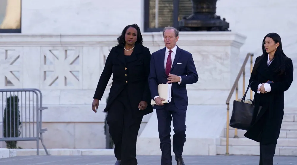 ليزا كوك لدى خروجها برفقة المحامي آبي لويل، من المحكمة العليا الأميركية (رويترز)