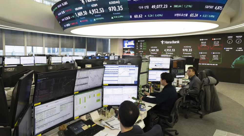 متداولون يعملون أمام شاشات في بنك هانا في سيول (إ.ب.أ)