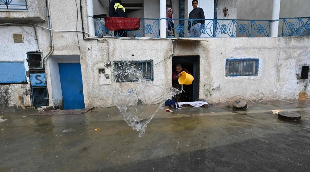  A man removes water from his flooded home in La Goulette, near the Tunisian capital Tunis. AFP 