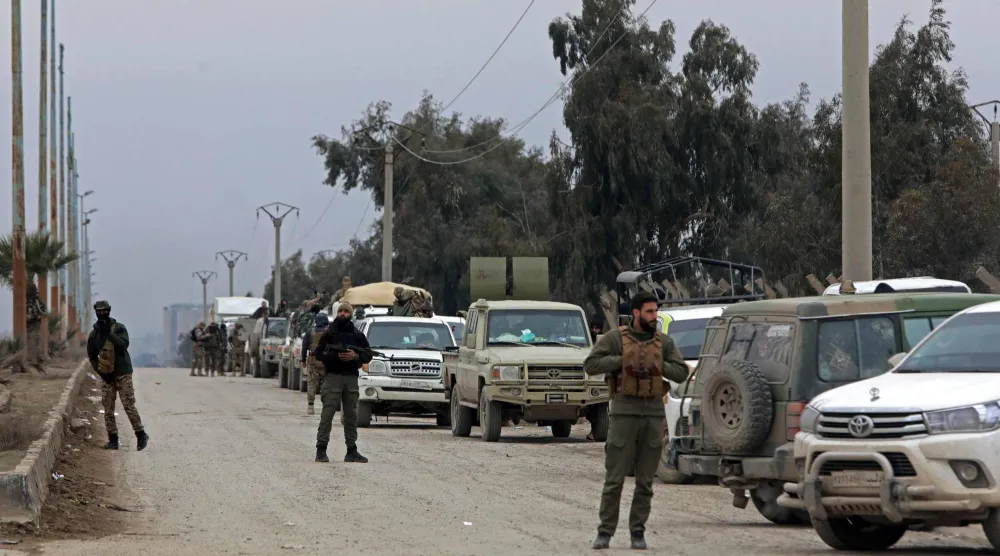 أفراد من قوات الأمن التابعة للحكومة السورية يحرسون على طول منطقة قريبة من سجن الأقطان على مشارف مدينة الرقة شمال شرقي سوريا يوم 22 يناير 2026 (أ.ف.ب)