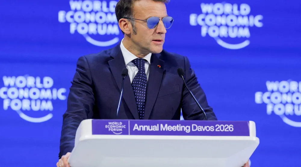 إيمانويل ماكرون يرتدي نظارة شمسية شبيهة لما يقتنيها الطيارون خلال كلمته أمام المنتدى الاقتصادي في دافوس (رويترز)