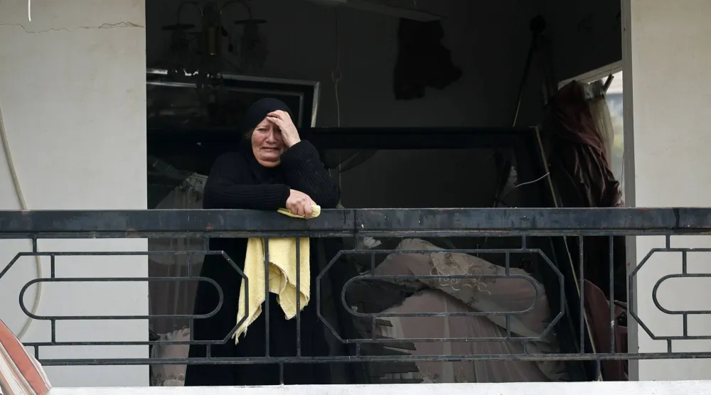 لبنانية متأثرة من الدمار الذي خلفته الغارات الإسرائيلية على بلدة قناريت الجنوبية الأربعاء (إ.ب.أ)