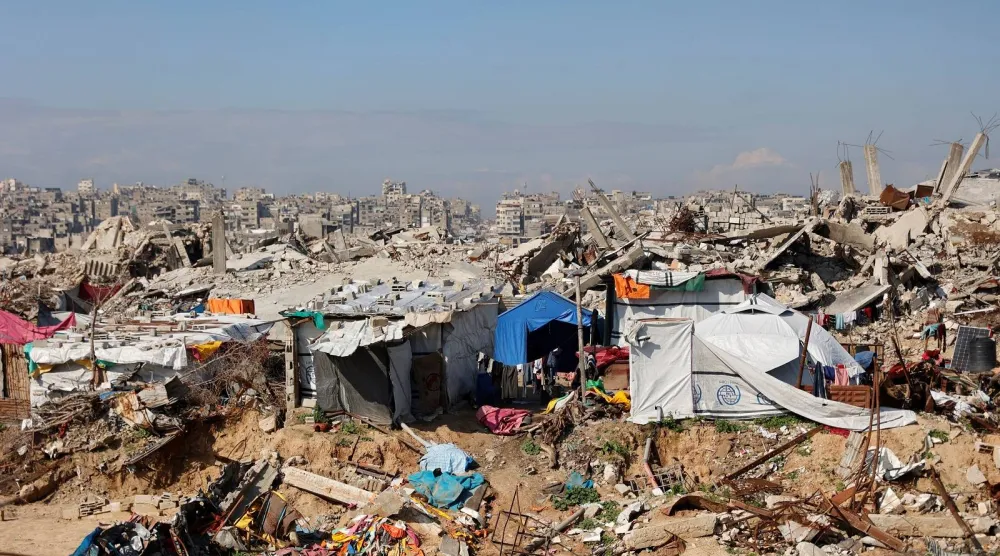 فلسطينيون نازحون يعيشون وسط الأنقاض والحطام الذي خلّفه الجيش الإسرائيلي في مخيم جباليا للاجئين شمال قطاع غزة (أ.ف.ب)