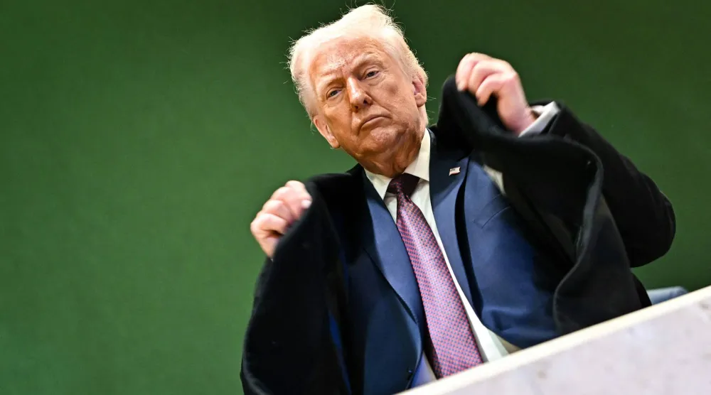 الرئيس الأميركي دونالد ترمب يرتب سترته وهو يغادر مركز المؤتمرات خلال الاجتماع السنوي للمنتدى الاقتصادي العالمي في دافوس (أ.ف.ب)