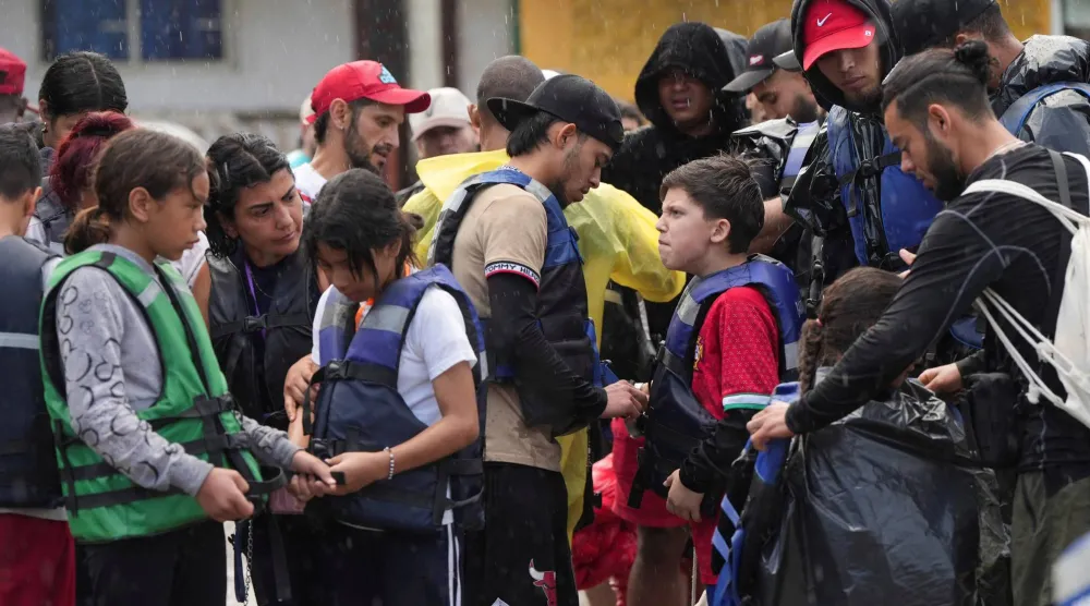 مهاجرون فنزويليون يساعدون أقاربهم على ارتداء سترات النجاة قبل ركوب قارب متجه إلى كولومبيا في حين يعود عدد من المهاجرين إلى فنزويلا بعد ترحيلهم أو فشل محاولاتهم لدخول الولايات المتحدة في ظل سياسات الهجرة الصارمة... في ميرامار ببنما 15 يناير 2026 (رويترز)