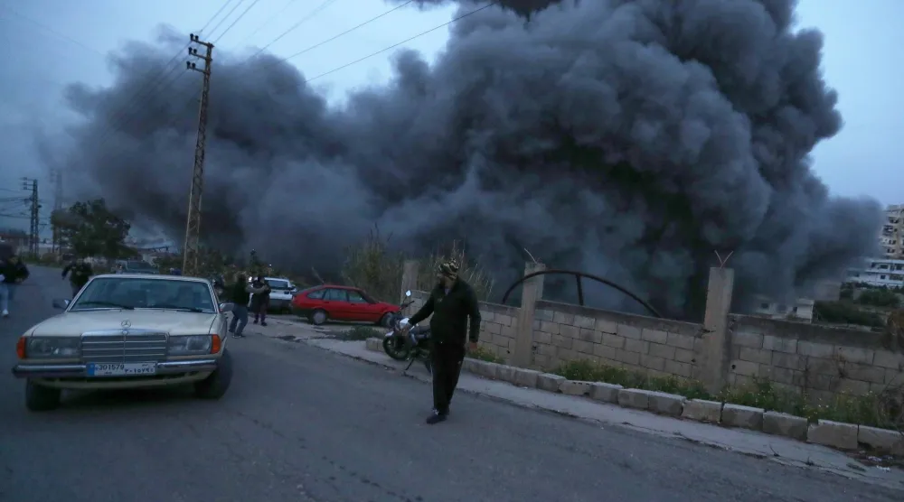 سكان محليون يهربون إلى الشارع لحظة استهداف إسرائيلي لبلدة قناريت بجنوب لبنان يوم 21 يناير (أ.ب)