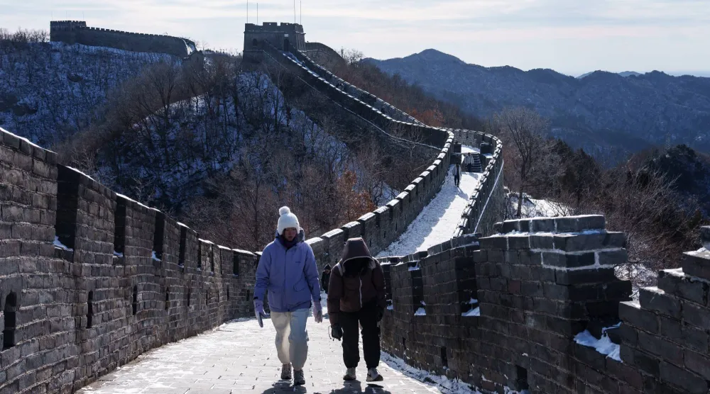 سائحان يسيران فوق سور الصين العظيم على تخوم العاصمة بكين (أ ب)