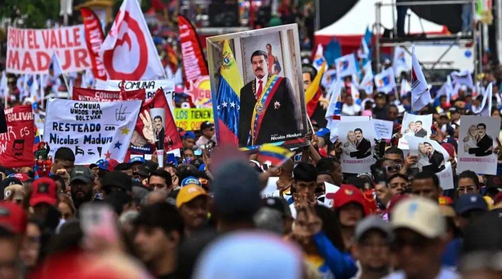 Devrik Venezuela Devlet Başkanı Nicolas Maduro'nun destekçileri, Maduro'nun fotoğraflarını ve serbest bırakılmasını talep eden pankartlar taşıdı (AFP)