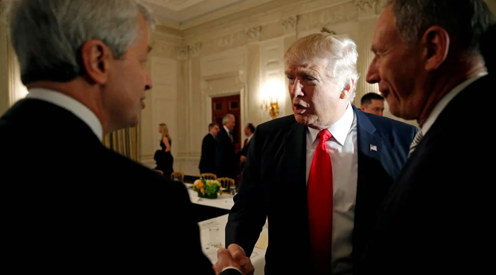 صورة تعود إلى عام 2017 تظهر ترمب يصافح دايمون خلال منتدى مع أكبر الشركات الأميركية (رويترز)