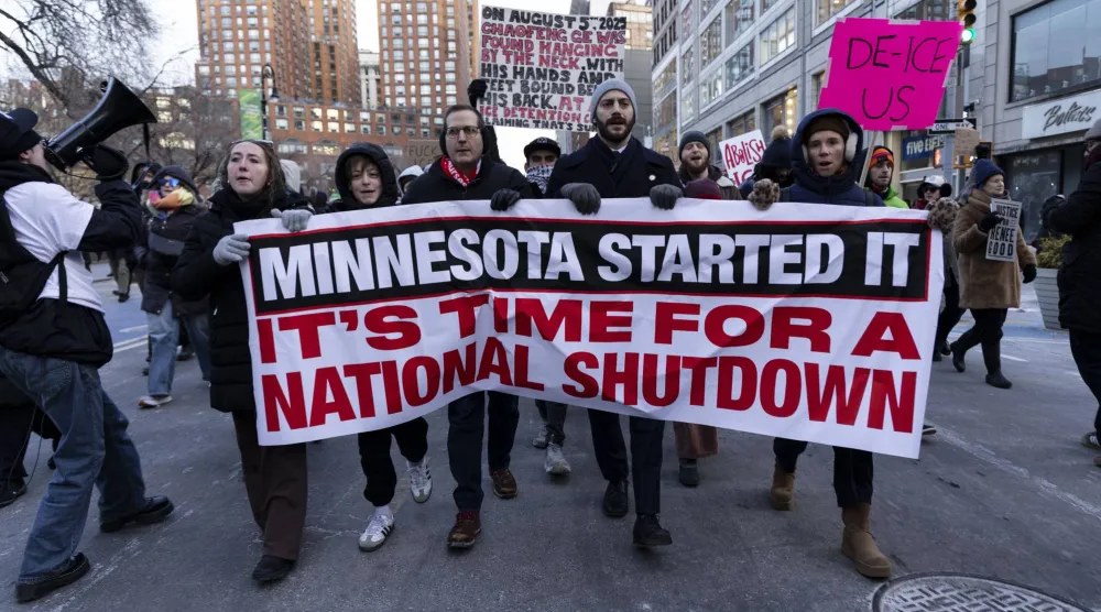 متظاهرون وأفراد من المجتمع رفعوا لافتة كُتب عليها «حان وقت إغلاق وطني» خلال تجمع احتجاجي طارئ في مينابوليس (د.ب.إ)