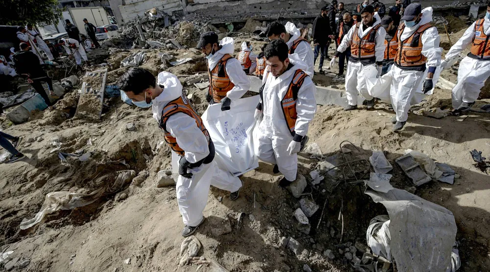 أفراد من الدفاع المدني خلال انتشال جثامين قتلى في مدينة غزة (إ.ب.أ)