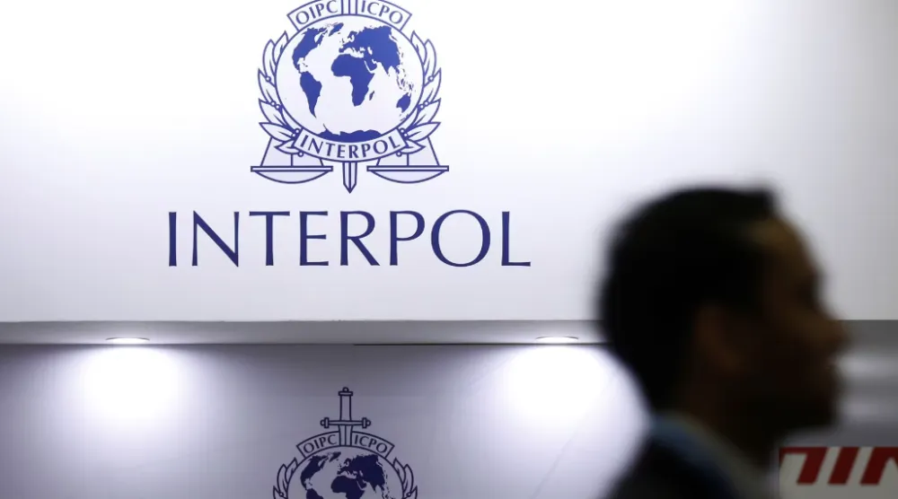 رجل يمر أمام شعار «الإنتربول» (رويترز)
