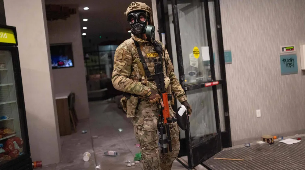 أحد عناصر قوات الأمن الفيدرالية داخل فندق شهد مظاهرات اعتراضاً على إقامة قوات الأمن به في مينيابوليس (أ.ف.ب)