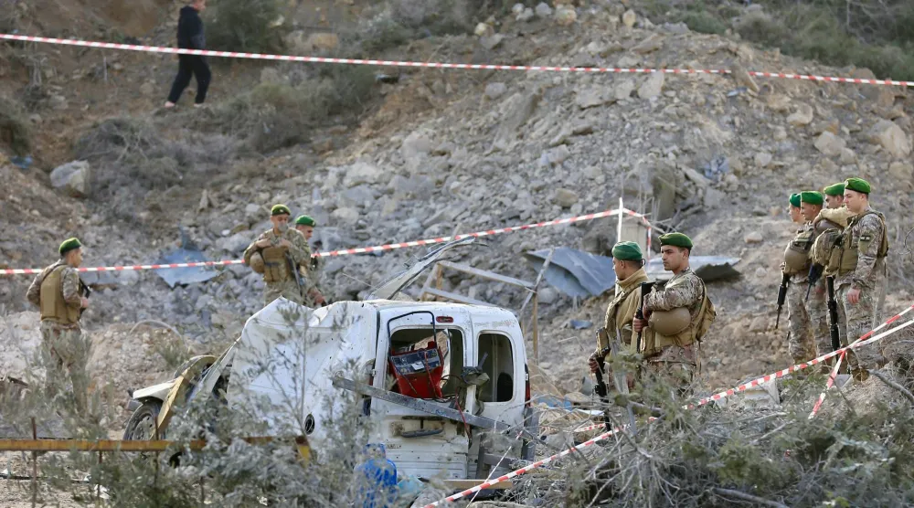 جنود من الجيش اللبناني وعمال الإنقاذ يتفقدون الأضرار الناجمة عن غارة جوية إسرائيلية استهدفت حظيرة طائرات صناعية في قرية كفر دونين بقضاء بنت جبال جنوب لبنان أمس (إ.ب.أ)