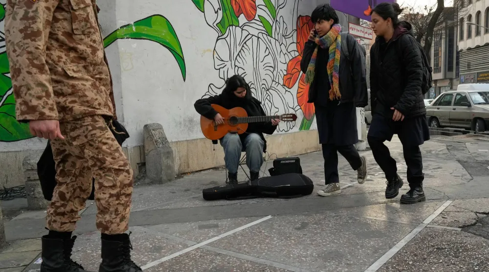 موسيقي يعزف على الغيتار في شارع وسط مدينة طهران (أ.ب)