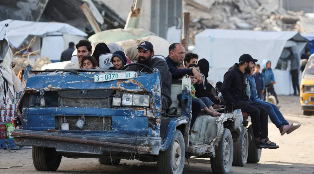 نازحون فلسطينيون يستقلون حافلة مهشمة للتنقل في مدينة غزة (رويترز)