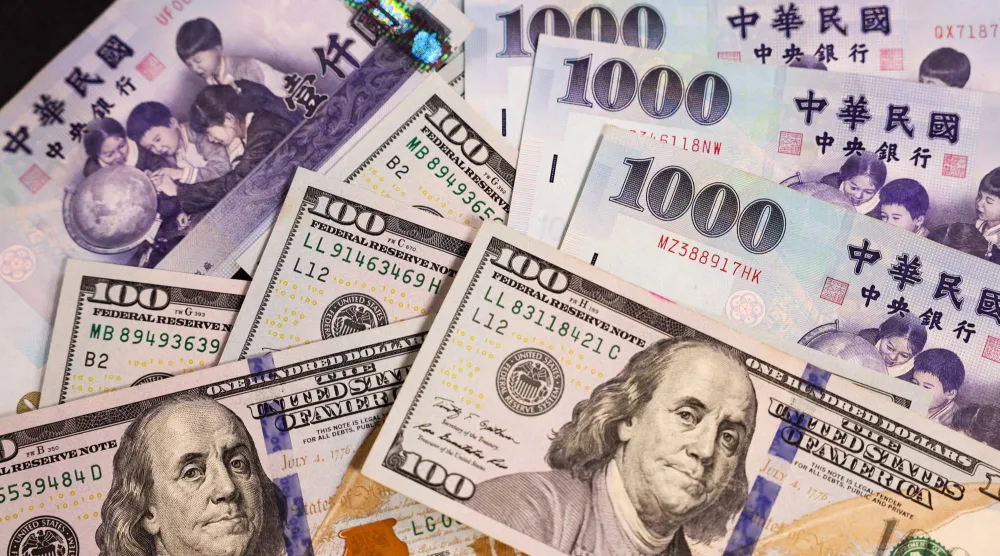 أوراق نقدية من فئة 100 دولار أميركي و1000 دولار تايواني (أ.ف.ب)