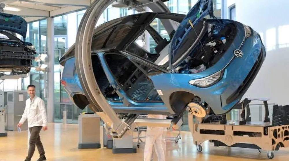 فنيون يعملون على خط تجميع سيارة «فولكس فاغن» الكهربائية «آي دي 3» خلال جولة إعلامية في دريسدن (رويترز)