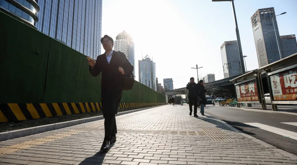 مشاة بشارع بالحي المالي في العاصمة الصينية بكين (إ ب.أ)