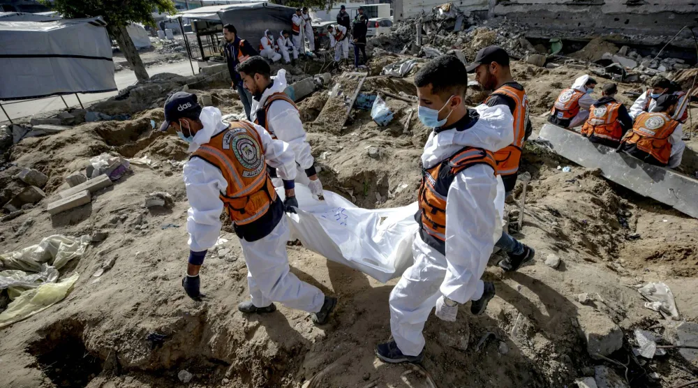 جانب من عملية إعادة دفن جثامين فلسطينيين في حي الزيتون بغزة (إ.ب.أ)