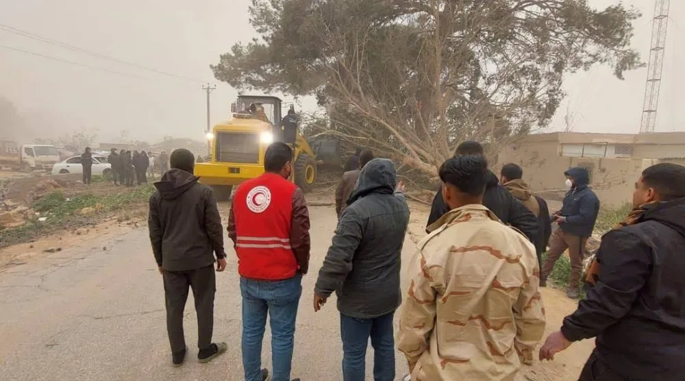 فريق طوارئ بالهلال الأحمر الليبي يزيل أشجاراً من الطريق أسقطتها العاصفة الجوية (الهلال الأحمر)