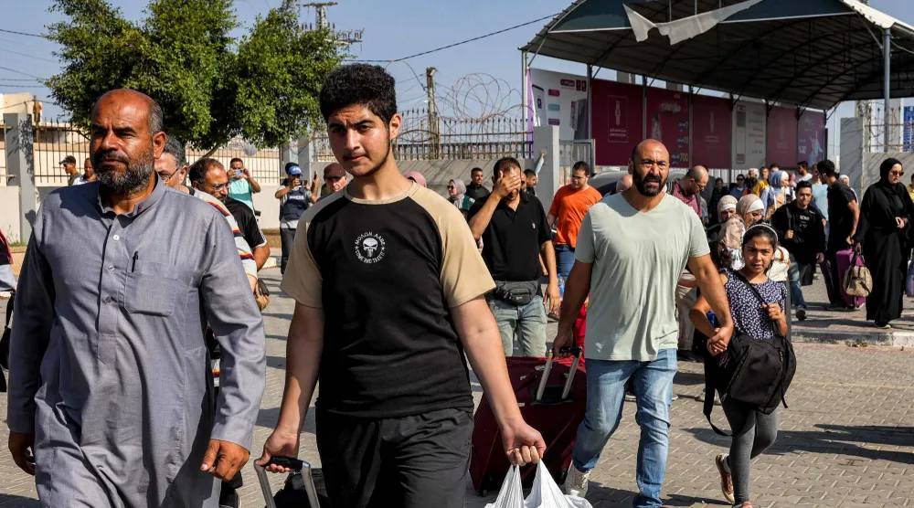 أشخاص يسيرون عبر بوابة للدخول إلى معبر رفح الحدودي إلى مصر في جنوب قطاع غزة في 1 نوفمبر 2023 (أ.ف.ب)