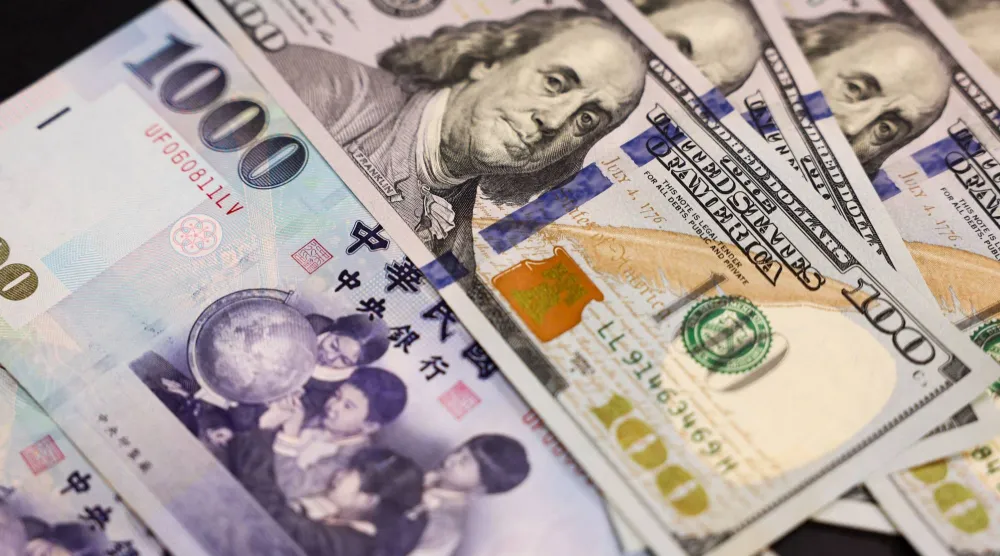 أوراق نقدية من فئة 100 دولار أميركي و1000 دولار تايواني (أ.ف.ب)