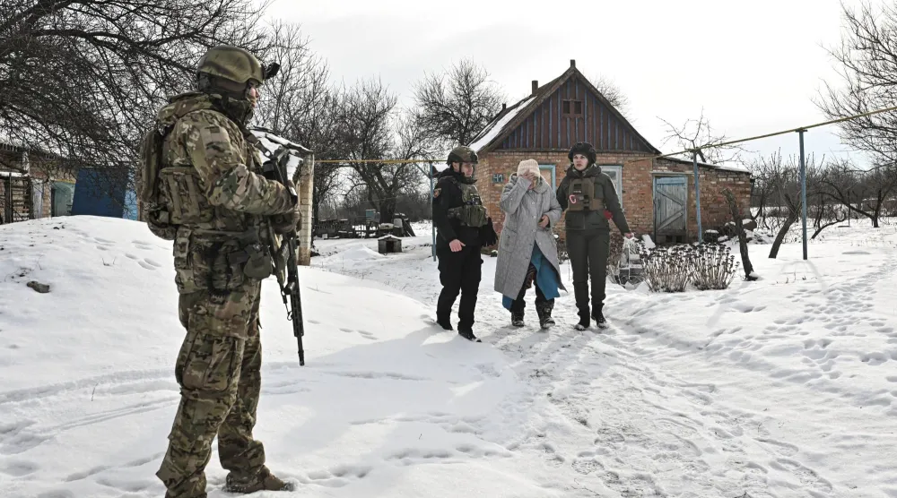 ضباط أوكرانيون يساعدون أحد السكان خلال عملية إجلاء من قرية على خط المواجهة وسط الهجوم الروسي على أوكرانيا في منطقة زابوريجيا (رويترز)