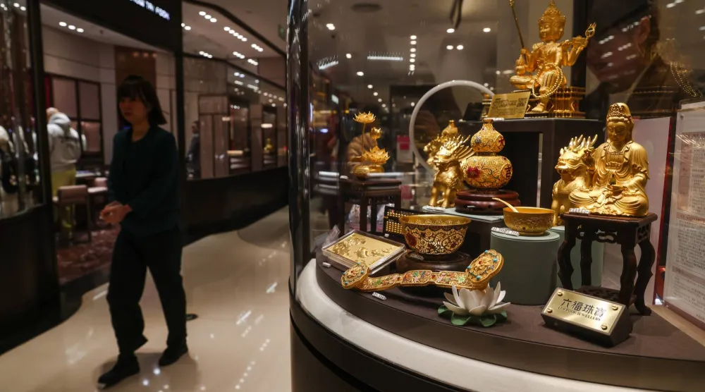 سيدة تمر أمام واجهة أحد متاجر الذهب في العاصمة الصينية بكين (إ.ب.أ)