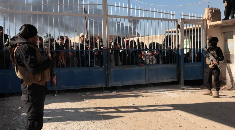 Suriye'nin kuzeydoğusunda DEAŞ üyelerinin ailelerinin kaldığı el-Hol Kampı’nın kapısının önünde duran Suriye güvenlik güçleri (EPA)