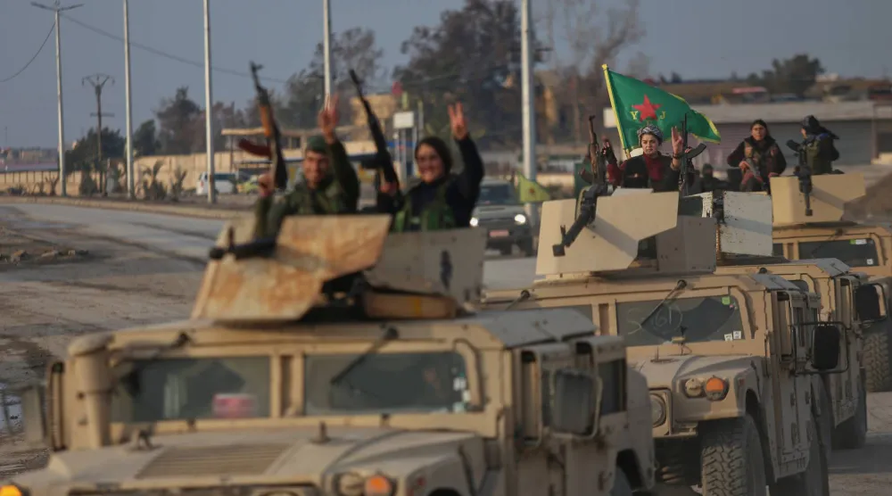 جنود كرد على عربات عسكرية لـ«قوات سوريا الديمقراطية» يشيرون بعلامات النصر في الحسكة (أ.ب)